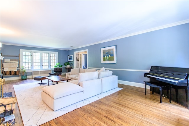 living room featuring radiator, light hardwood / wood-style flooring, and ornamental molding