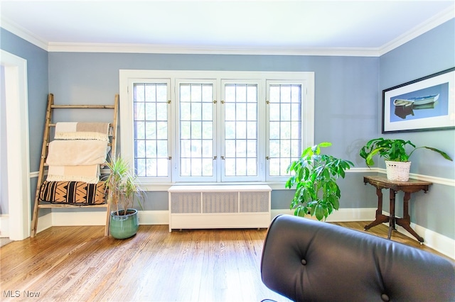 living area with radiator, light hardwood / wood-style flooring, and crown molding