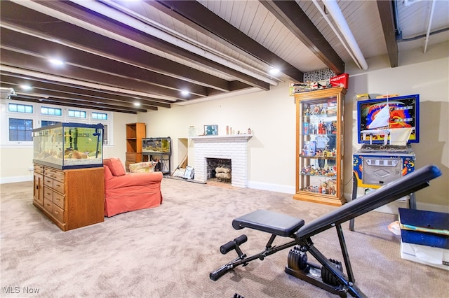 exercise area featuring a fireplace and light carpet