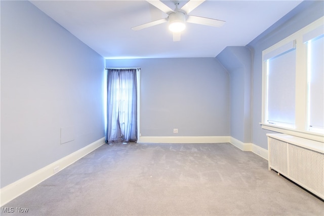 bonus room featuring radiator heating unit, light carpet, and ceiling fan