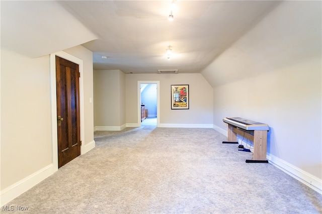 additional living space featuring light carpet and lofted ceiling