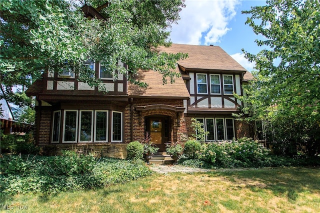 tudor-style house featuring a front lawn