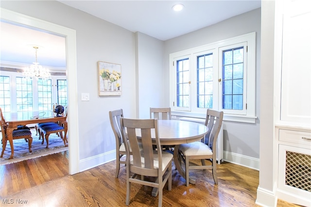 dining room with hardwood / wood-style flooring and an inviting chandelier