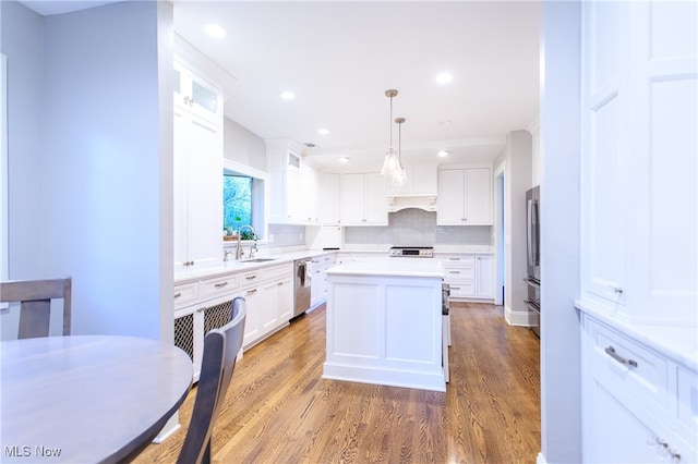 kitchen featuring white cabinetry, stainless steel appliances, pendant lighting, and a center island