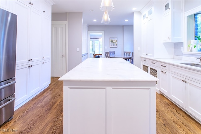 kitchen featuring wood-type flooring, stainless steel fridge, and a center island