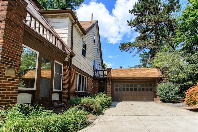 view of side of property featuring a garage and a balcony