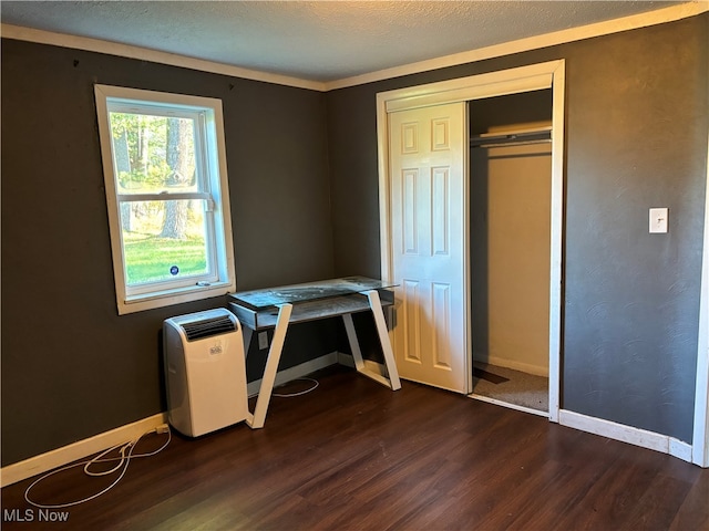 interior space featuring a textured ceiling, a closet, and dark hardwood / wood-style flooring