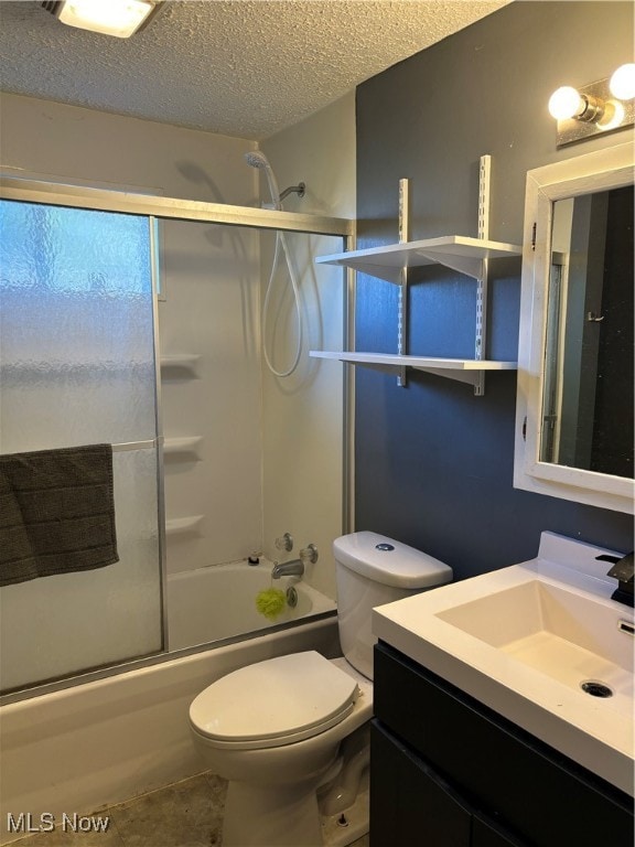 full bathroom featuring toilet, combined bath / shower with glass door, vanity, and a textured ceiling