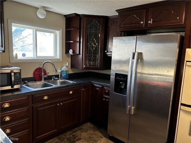 kitchen with stainless steel appliances, dark brown cabinets, a textured ceiling, and sink