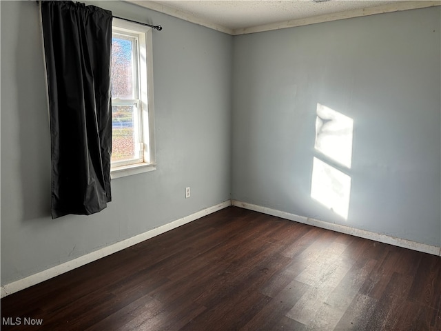 empty room featuring dark wood-type flooring and a textured ceiling