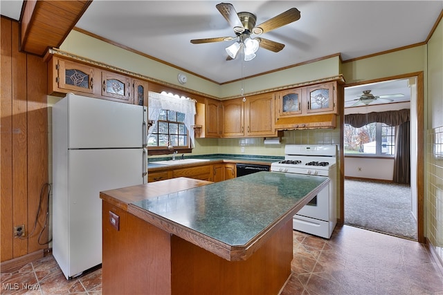 kitchen with sink, tasteful backsplash, white appliances, a kitchen island, and carpet floors