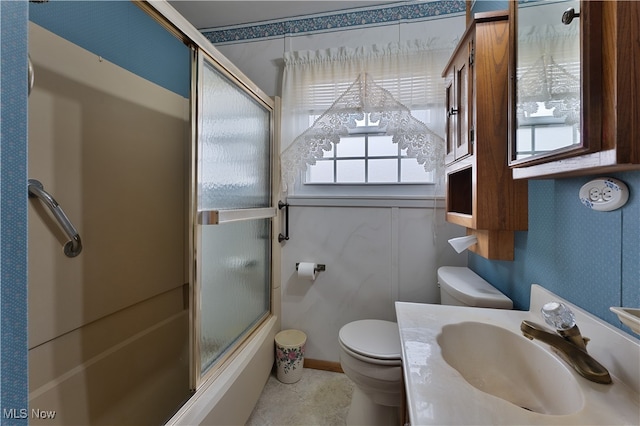 full bathroom featuring toilet, combined bath / shower with glass door, and vanity