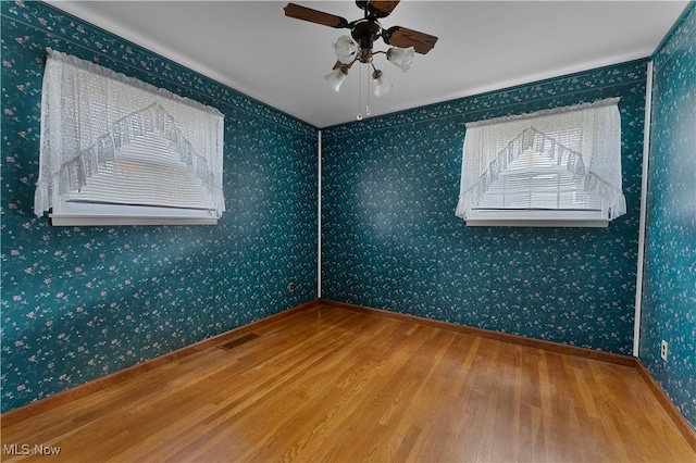 empty room with hardwood / wood-style flooring and ceiling fan