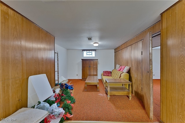 recreation room featuring wooden walls and light carpet