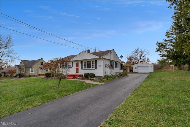 ranch-style home with a garage, a front yard, and an outbuilding