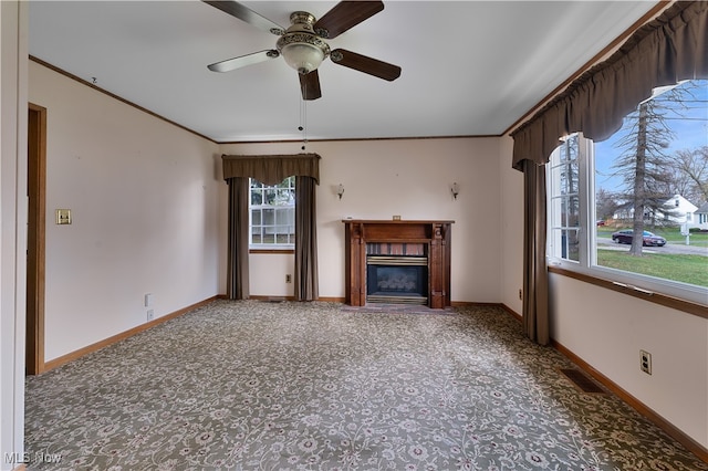 unfurnished living room featuring ornamental molding, plenty of natural light, and ceiling fan