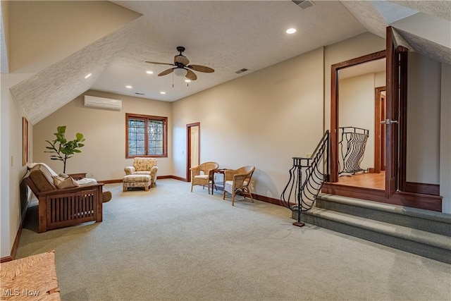 sitting room with a wall mounted air conditioner, carpet flooring, a textured ceiling, ceiling fan, and lofted ceiling