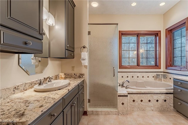 bathroom with plus walk in shower, vanity, and tile patterned flooring