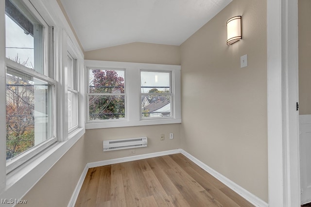 spare room featuring light hardwood / wood-style flooring, lofted ceiling, and a wall mounted air conditioner