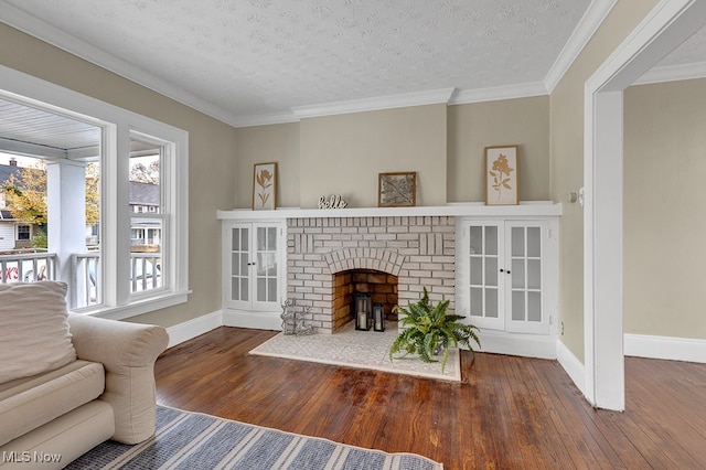 living room with a textured ceiling, hardwood / wood-style flooring, ornamental molding, and a fireplace