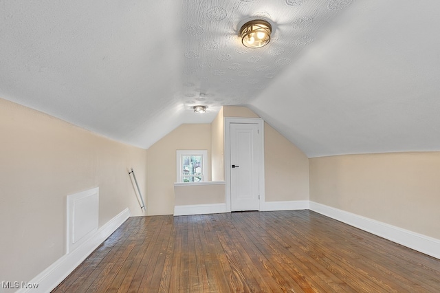 bonus room featuring vaulted ceiling, dark hardwood / wood-style floors, and a textured ceiling