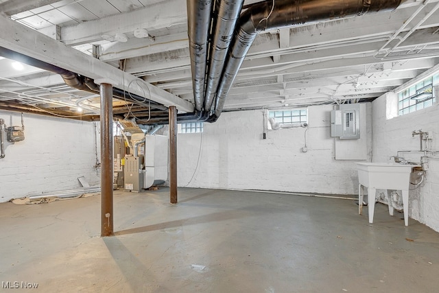 basement featuring electric panel and heating unit