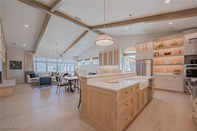 kitchen featuring pendant lighting, vaulted ceiling with beams, sink, and stainless steel refrigerator