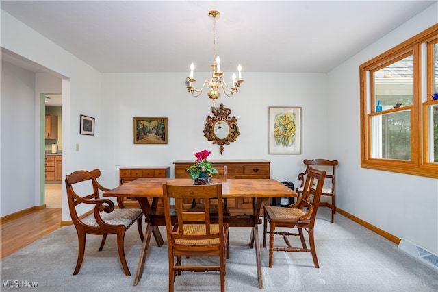 dining room with hardwood / wood-style flooring and a chandelier