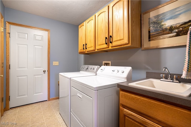 laundry area with sink, cabinets, independent washer and dryer, and a textured ceiling