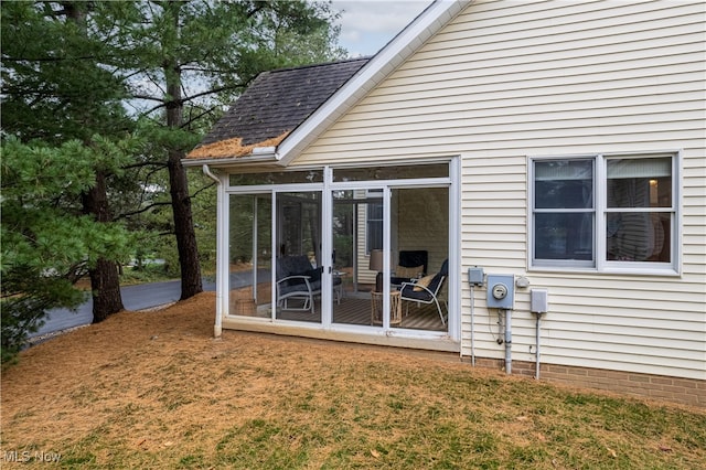 rear view of house with a sunroom and a yard