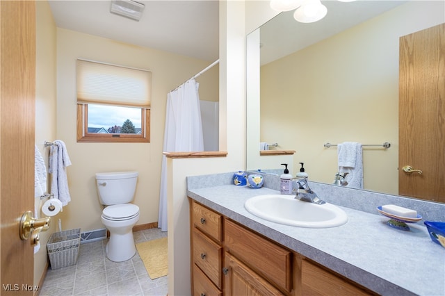 bathroom with toilet, vanity, and tile patterned floors