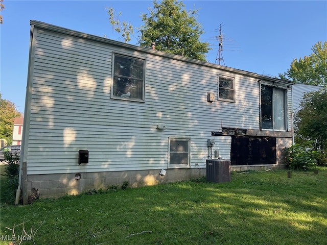 rear view of property with a yard and cooling unit