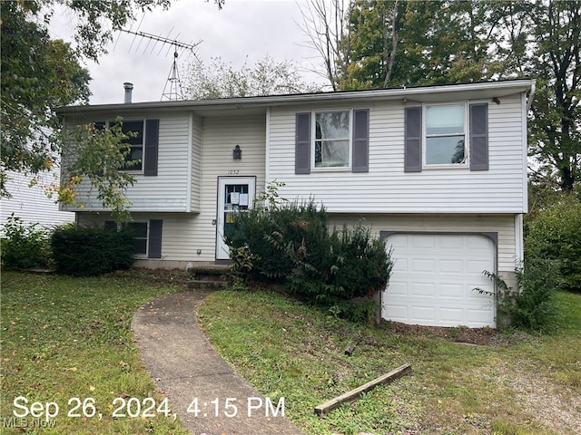 split foyer home featuring a garage and a front yard