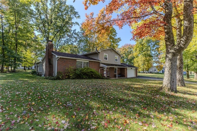 view of side of property featuring a garage and a yard