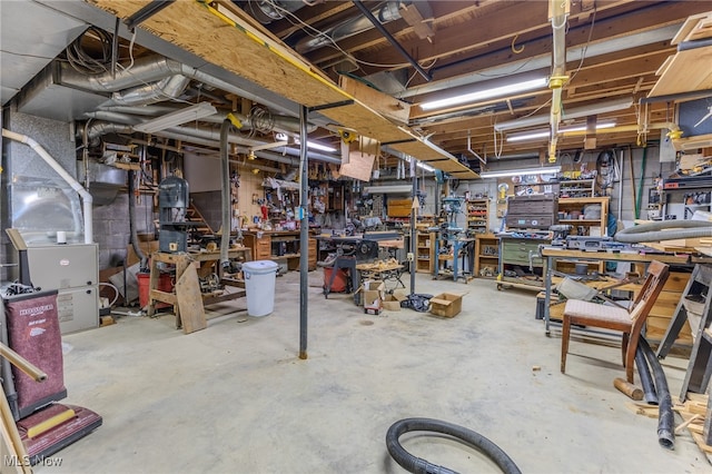 basement featuring a workshop area and heating unit