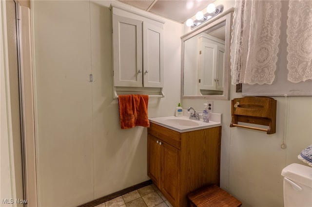 bathroom featuring tile patterned flooring, vanity, and toilet