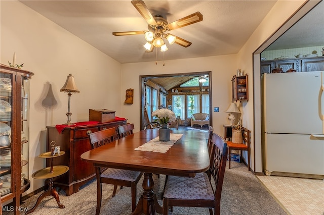 carpeted dining space with ceiling fan