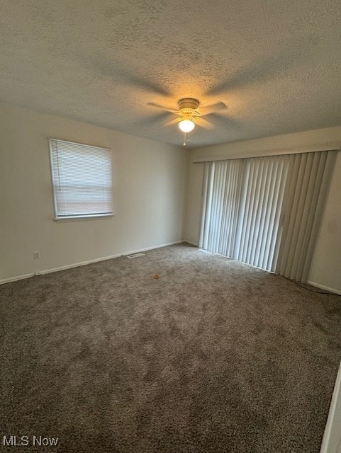 unfurnished room with ceiling fan, a textured ceiling, and carpet floors