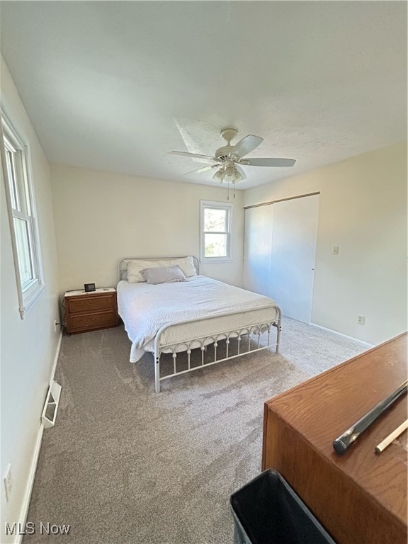 carpeted bedroom featuring a closet and ceiling fan