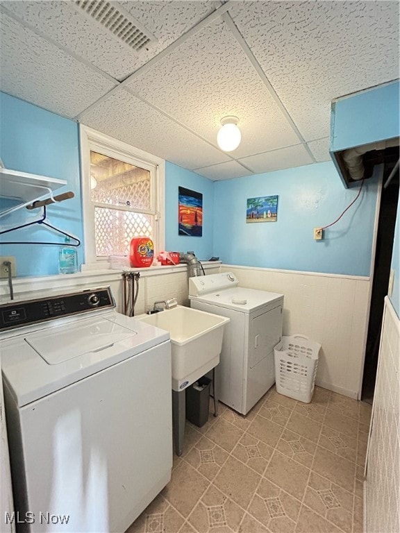 laundry area with sink, washer and dryer, and light tile patterned floors