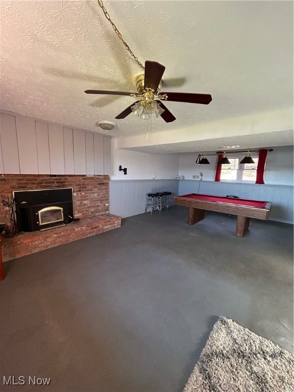 playroom with ceiling fan, a textured ceiling, billiards, and concrete floors