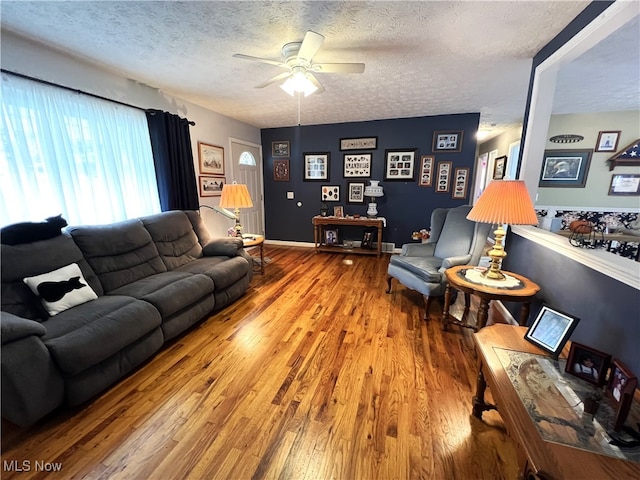 living room featuring a textured ceiling, ceiling fan, and hardwood / wood-style floors