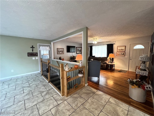 living room with a textured ceiling and ceiling fan