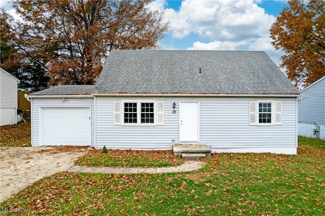 rear view of house with a garage and a lawn