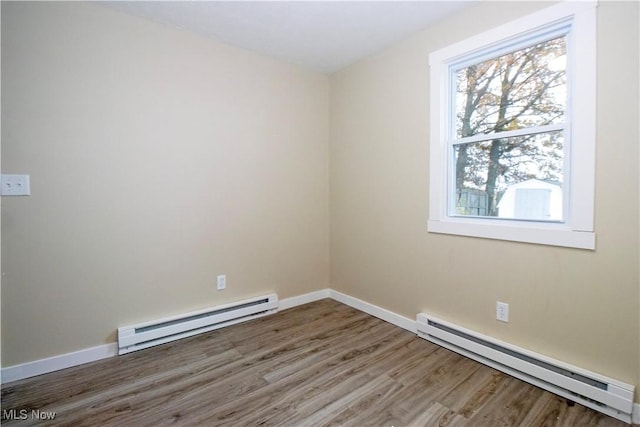 unfurnished room with wood-type flooring and baseboard heating