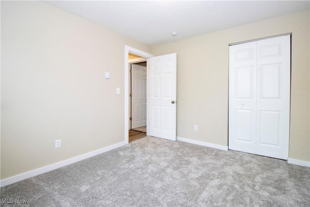 unfurnished bedroom featuring light colored carpet and a closet