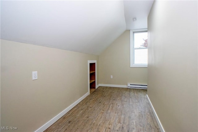 bonus room featuring light hardwood / wood-style flooring, vaulted ceiling, and baseboard heating