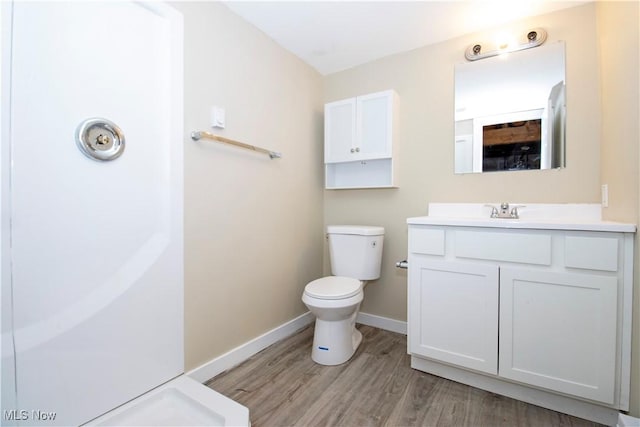 bathroom with hardwood / wood-style floors, vanity, and toilet