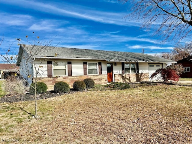 ranch-style house featuring a garage and a front lawn