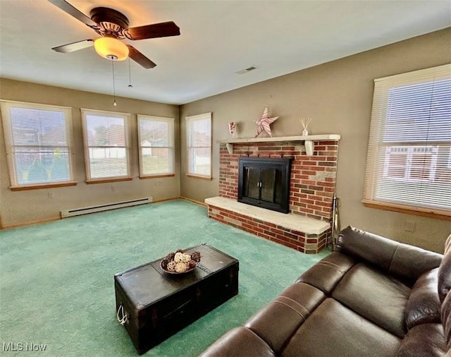 living room featuring a wealth of natural light, carpet, a brick fireplace, and a baseboard heating unit